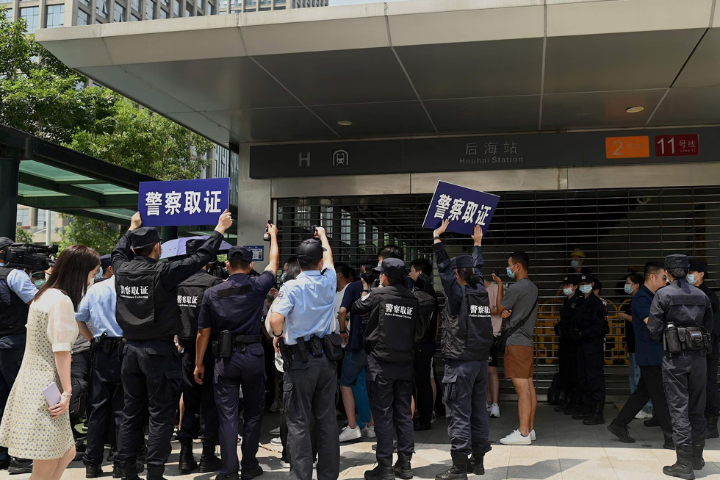 chineses com placas de protesto em frente a edifício na China