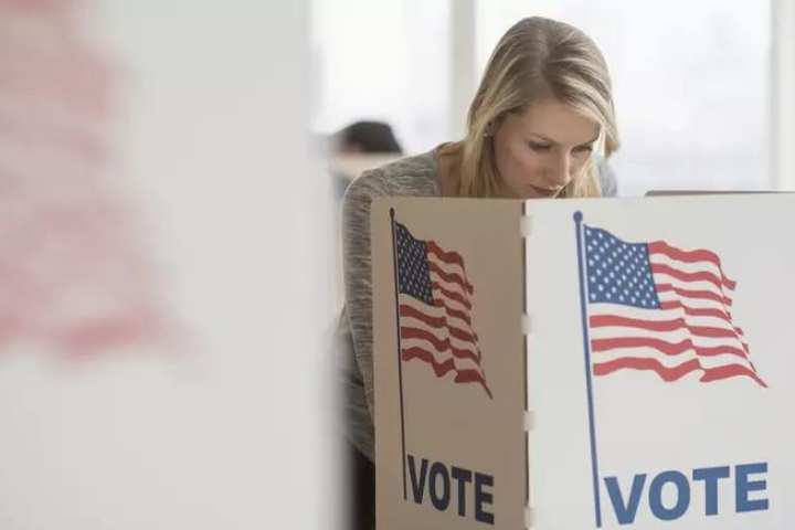 Mulher votando em uma urna nos EUA, representando as eleições